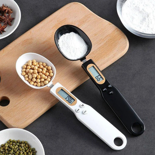 Digital measuring spoon with digital display on a wooden cutting board with ingredients.